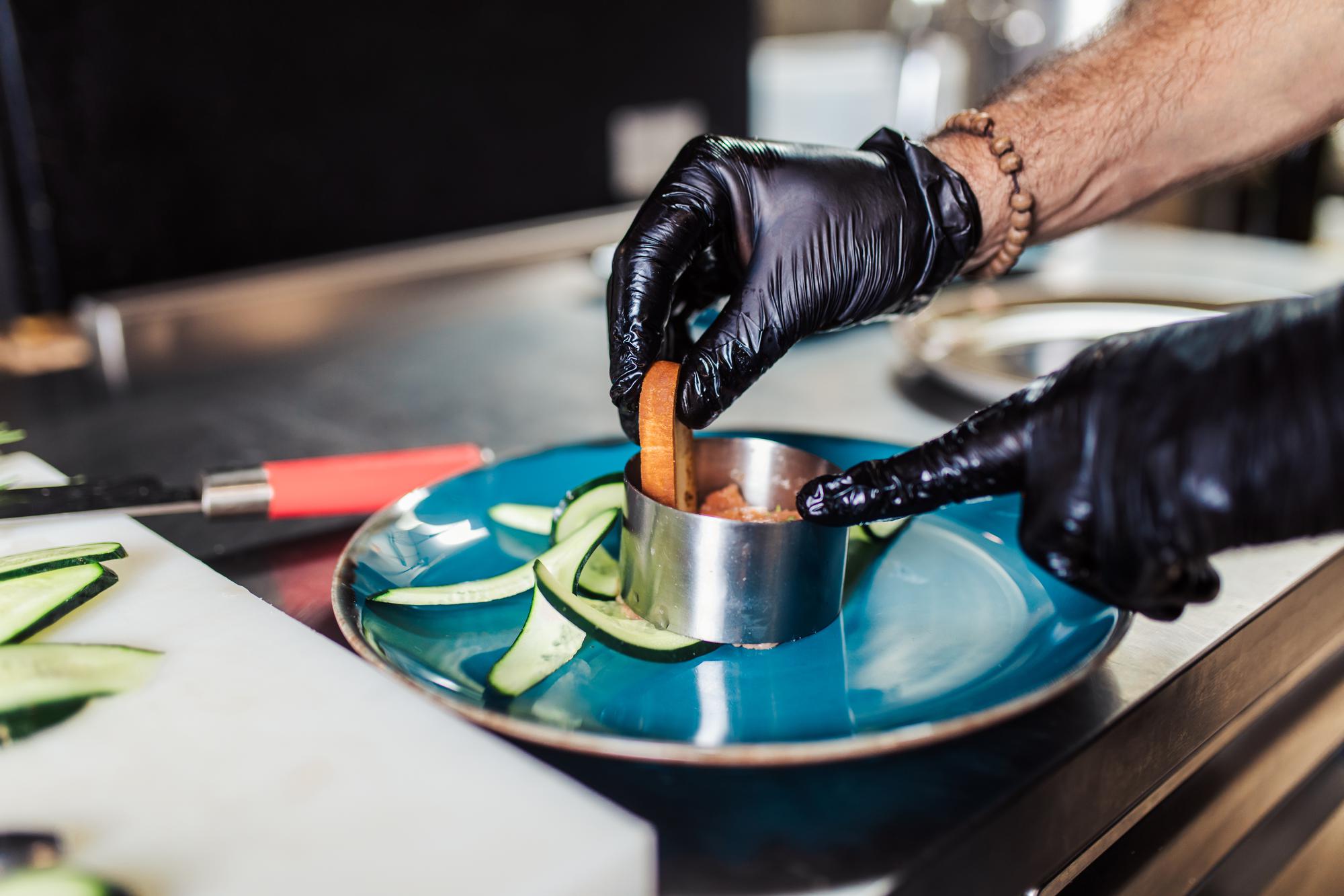 Chef preparing a plated modern dish with precise tools